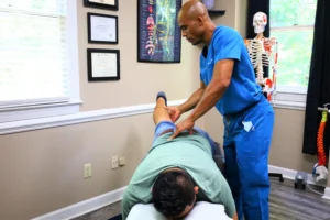 Patient receiving spinal adjustment during her first visit to the chiropractor to relieve chronic pain without medication.
