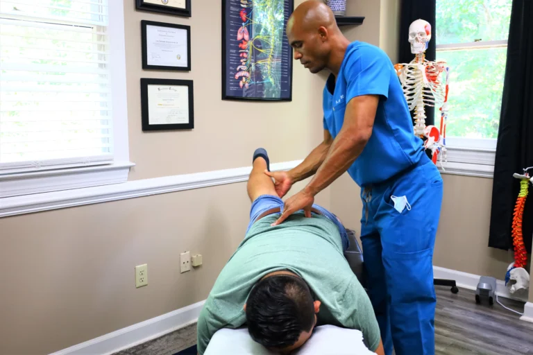 Patient receiving spinal adjustment during her first visit to the chiropractor to relieve chronic pain without medication.