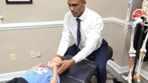 Smiling child receiving a gentle adjustment at a chiropractic clinic, depicting chiropractic care for children.