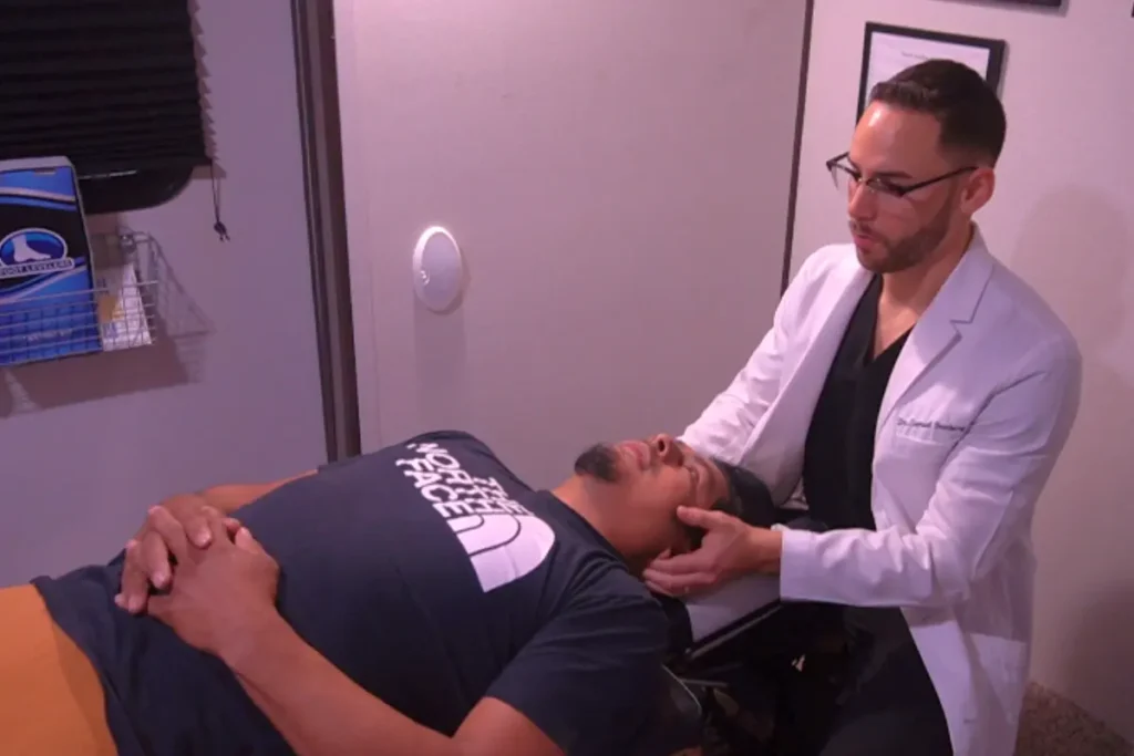 Doctor quiropráctico bilingüe evaluando dolor de cuello en paciente latino días después de un accidente de auto