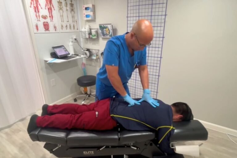 Doctor quiropráctico bilingüe atendiendo a paciente latino después de un accidente de auto en clínica ChiroDuo